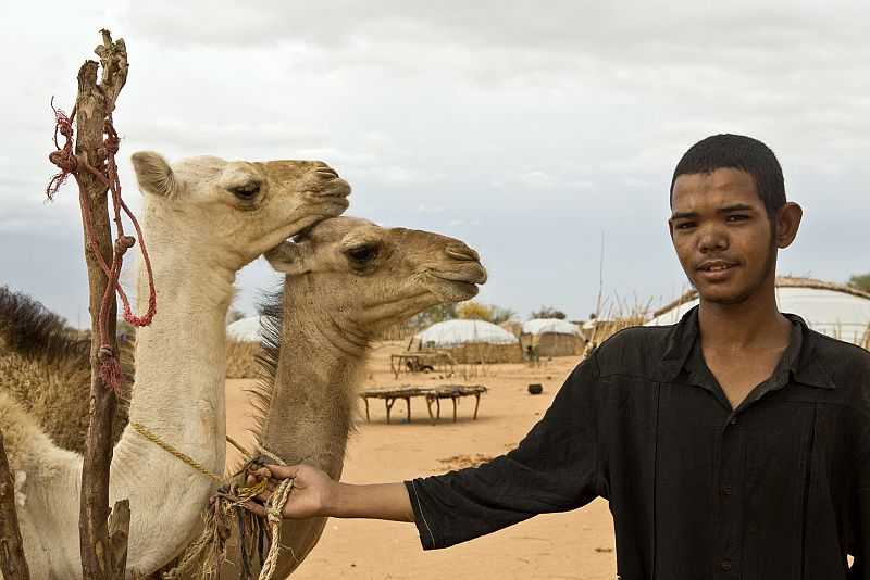 Ahmadou, de 18 años de edad, muestra con orgullo sus dos crías de camello en el campamento de Damba, en Burkina Faso.