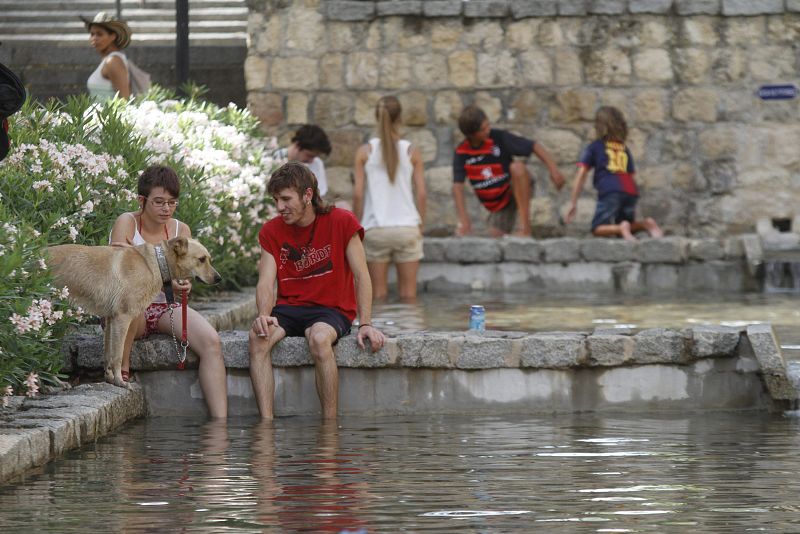 Jovenes meten sus pies en una fuente de Cordoba para refrescarse