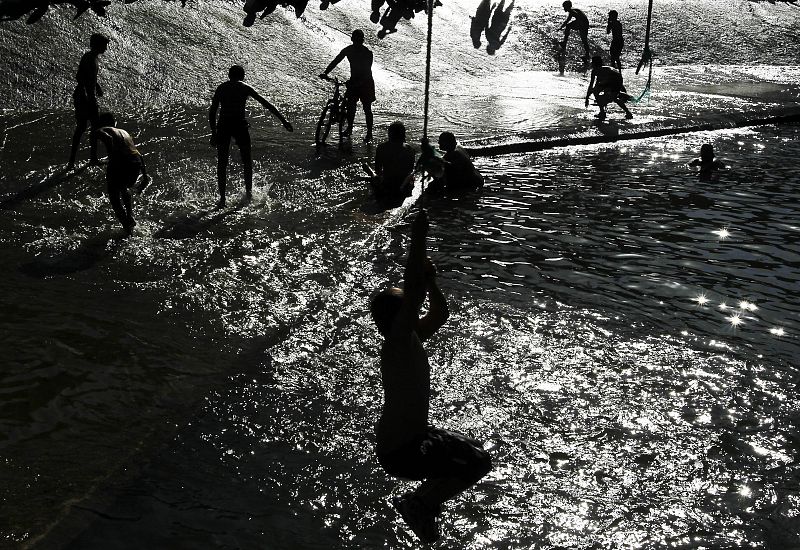 Un grupo de personas se baña en el rio Arga en Pamplona, Navarra