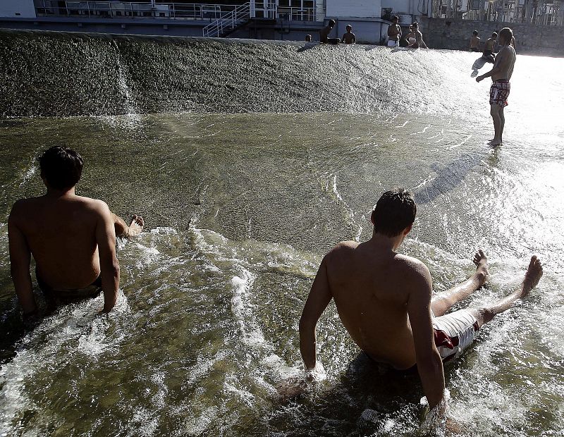 Niños y mayores se bañan en el rio Arga a su paso por Pamplona en Navarra donde las temperaturas alcanzaban los 39 grados