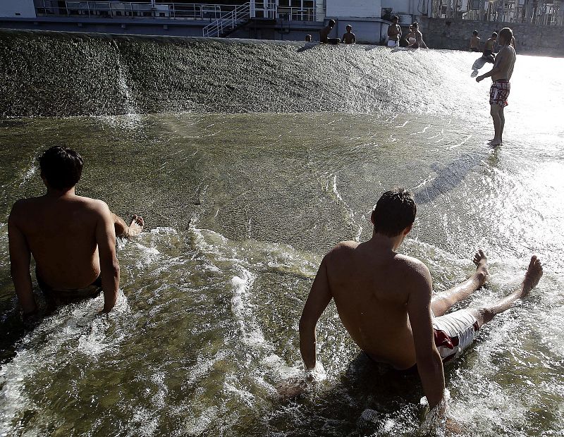 Niños y mayores se bañan en el rio Arga a su paso por Pamplona en Navarra donde las temperaturas alcanzaban los 39 grados