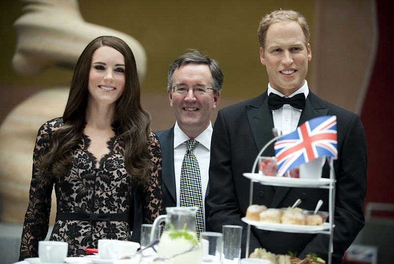 Los duques de Cambridge de cera posando con el viceembajador británico en Alemania, Andrew Noble