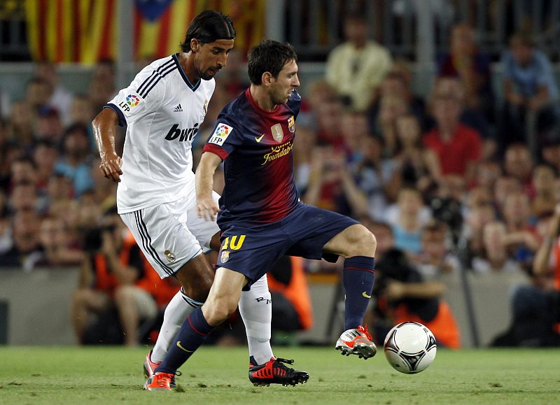 Messi controla el balón ante el mediocentro alemán del Real Madrid Khedira.
