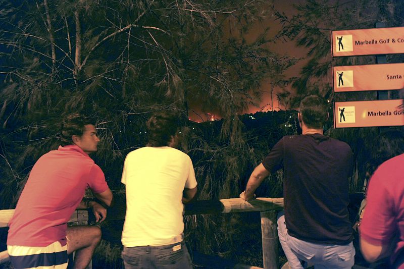 Vecinos esperan fuera de sus casas a que acabe el fuego en la zona de Santa Clara Golf, en Malaga