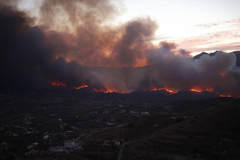 El fuego se deja ver cerca de las casas del municipio de Coin, Malaga, avivado por el viento y las altas temperaturas