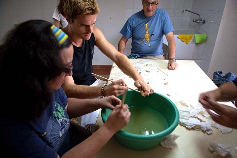 Varios voluntarios lavan las piezas recogidas en las excavaciones