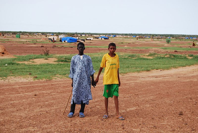 Dos jóvenes se dan la mano en uno de los campos de refugiados más poblado de Burkina Faso, el de Ferreiro, con más de 20.000 personas, según las últimas estimaciones.