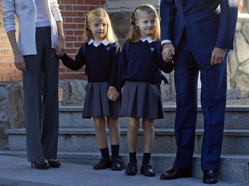 Leonor y Sofía vestían el uniforme  escolar -con jersey azul y falda gris- y mostraban una tímida sonrisa.