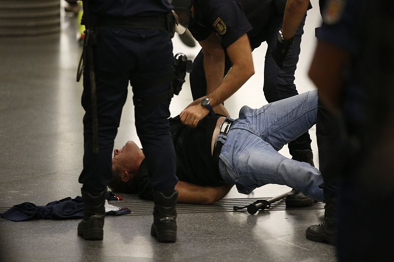 Agentes de policía detienen a uno de los miembros del piquete informativo en Atocha