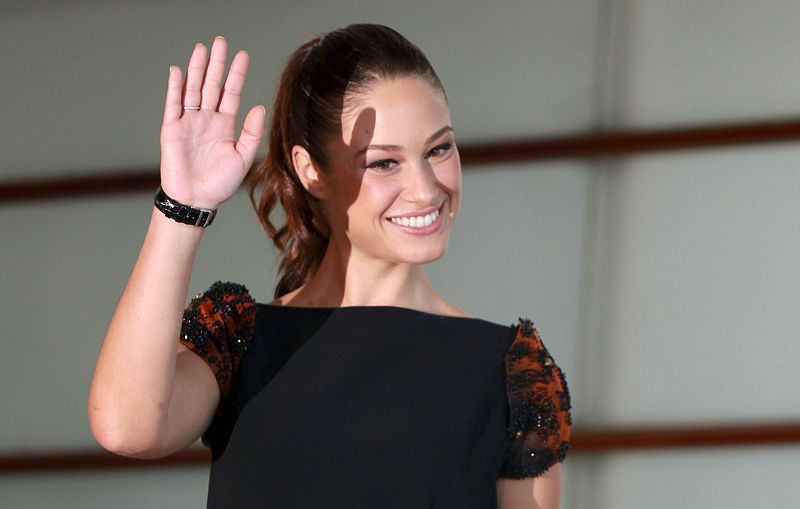 Aida Folch, con vestido negro con unas originales mangas en color rojo y con pedrería.