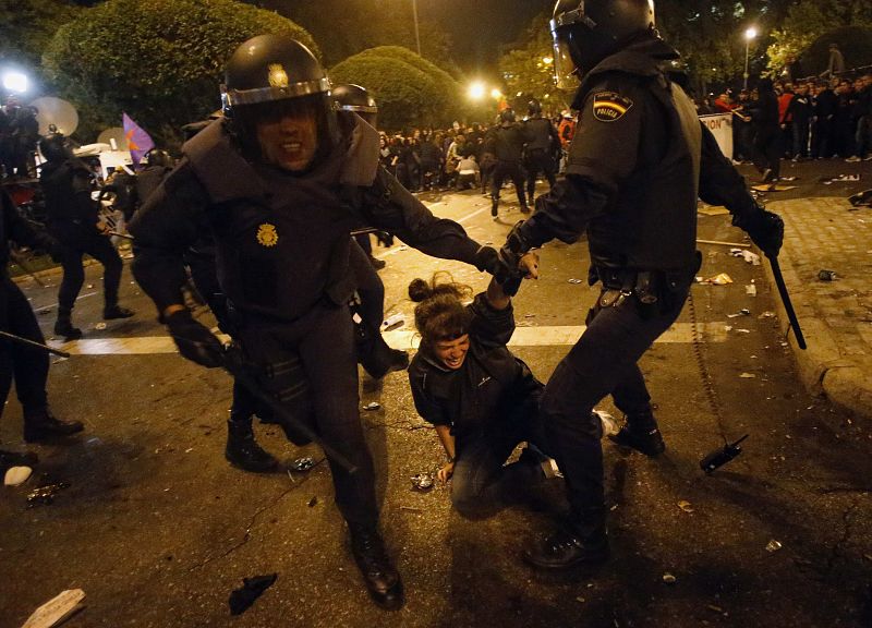 Protester cries out as she is dragged away by riot police outside Spain's parliament in Madrid