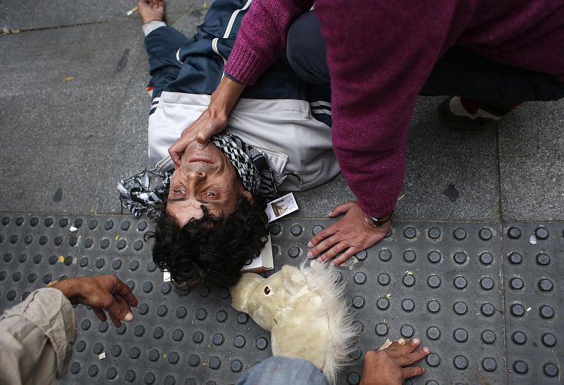 Protester lies injured on ground after riot police charged demonstrators outside Spanish parliament in Madrid