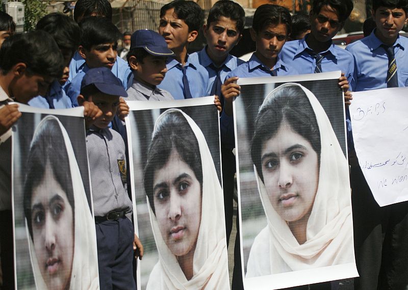 Students hold pictures of schoolgirl Yousufzai, who was shot by the Taliban, at a school in Karachi