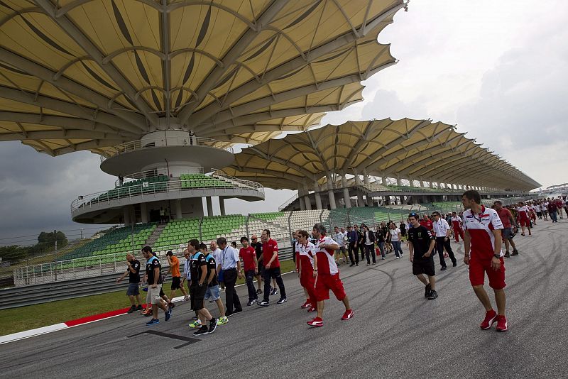 Técnicos y pilotos caminan hacia la curva 11 del circuito de Sepang para rendir tributo a Simoncelli