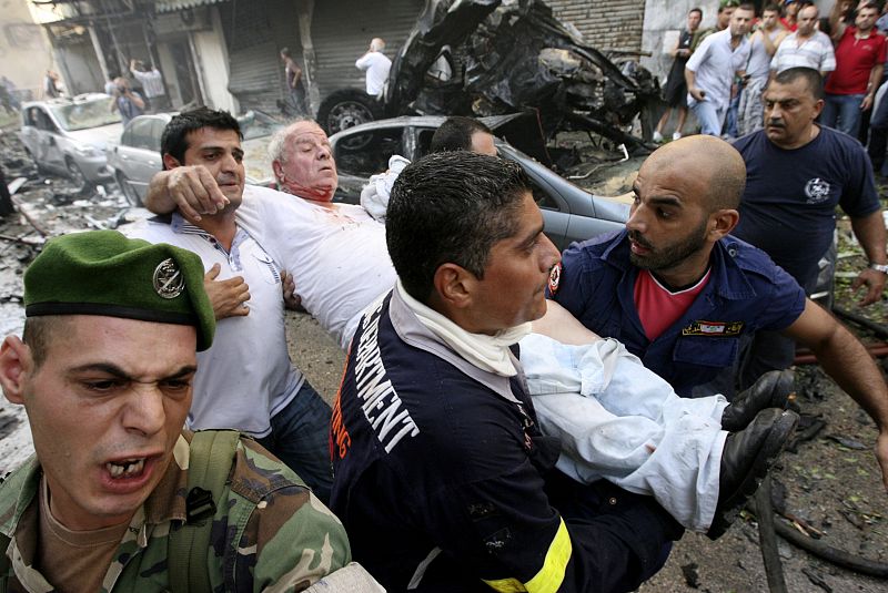 Vecinos y militares evacuan a los heridos en el atentado con coche bomba en el barrio de Ashafriyeh, en Beirut.