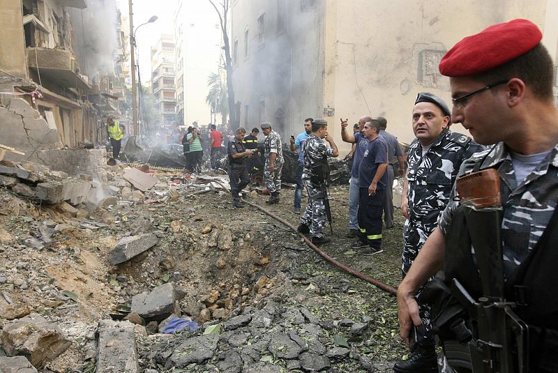 Policías libaneses observan el cráter de la explosión.