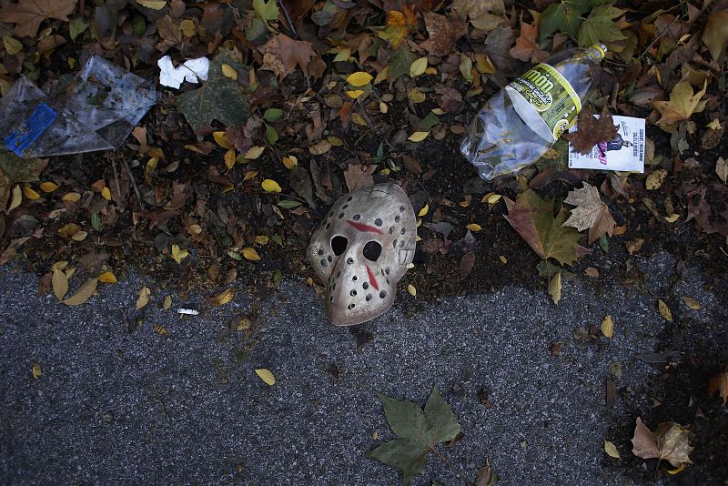 A Halloween mask is seen next to empty bottles and trash at the parking lot outside the Madrid Arena Stadium in Madrid