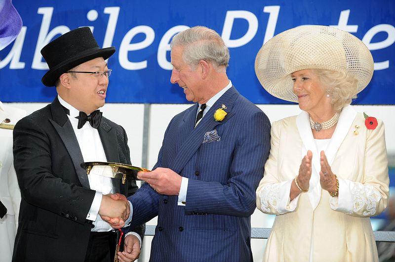 El príncipe Carlos y Camilla con el ganador de la carrera.