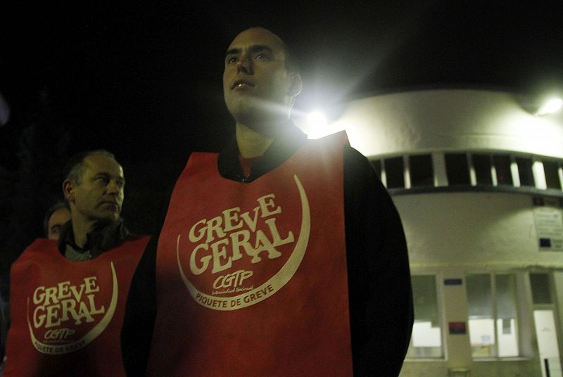 Piquetes con un mono en el que se lee "huelga general" permanecen de pie frente a una fábrica de cristal en  Santa Iria Azoia.