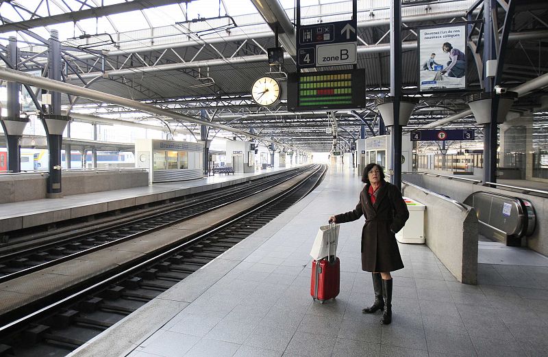 Una pasajera espera el tren en un andén vacío de una estación de ferrocarriles de Bruselas