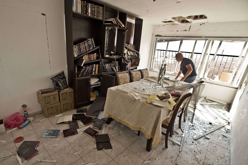 Un zapador israelí inspecciona los daños de una casa alcanzado por un cohete lanzado desde Gaza en la ciudad israelí de Kiryat Malahi.