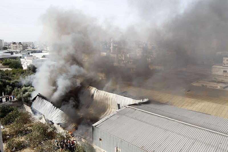 Bomberos palestinos tratan de extinguir el fuego en unaa fábrica en Beit Lahia, en el norte de Gaza.