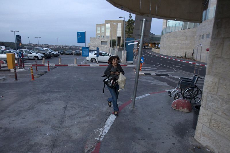 Una mujer israelí corre a refugiarse en un hospital de Jerusalén al oir el sonido de las alarmas antiaéreas.