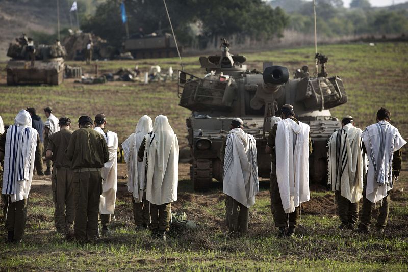 El Ejército israelí se mantiene en la frontera. Aquí, soldados rezando frente a una batería artillera