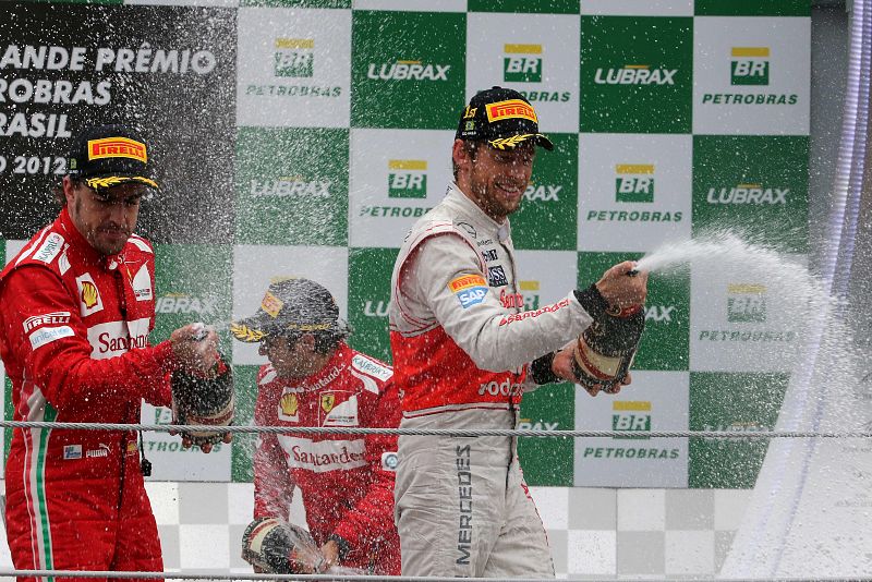 El piloto británico Jeson Button (d), de McLaren; el español Fernando Alonso (i), de Ferrari, y el brasileño Felipe Massa (c), de Ferrari, celebran en el podio