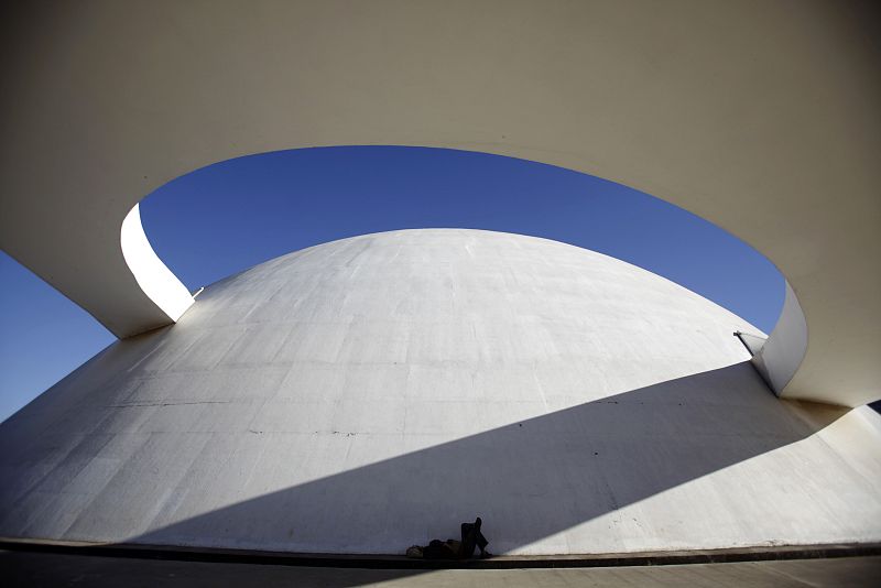File photo of a homeless person sleeping outside the National Museum designed by architect Oscar Niemeyer in Brasilia