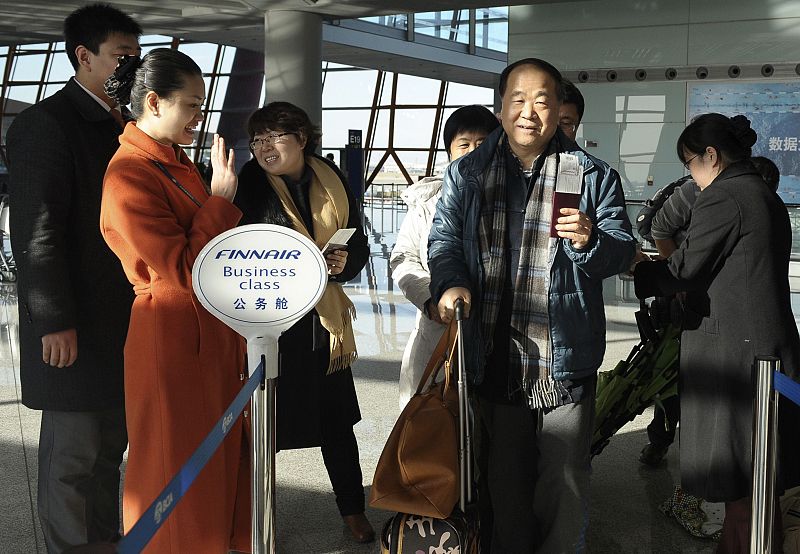 Chinese Nobel Literature Prize winner Yan holds his passport as he waits for boarding a plane at Beijing airport