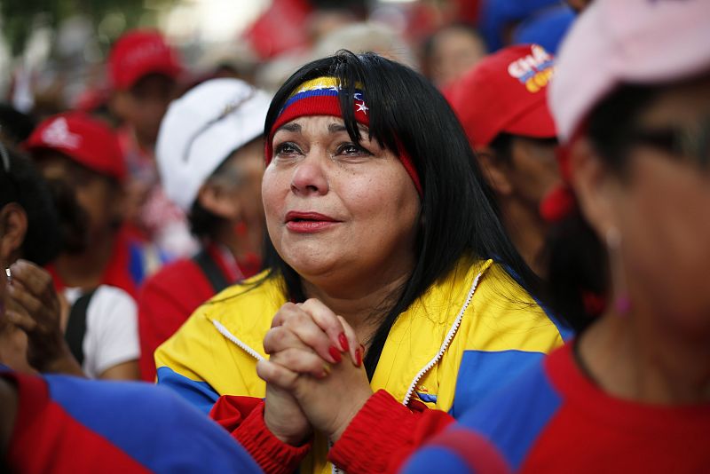 Una mujer llora y reza en la plaza Bolivar de Caracas