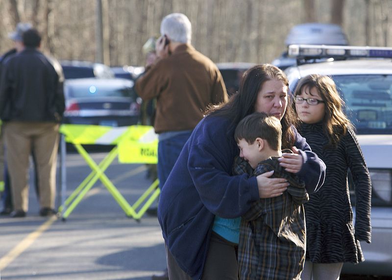 Un niño es reconfortado por una mujer fuera de la Sandy Hook Elementary School tras el tiroteo en Newtown