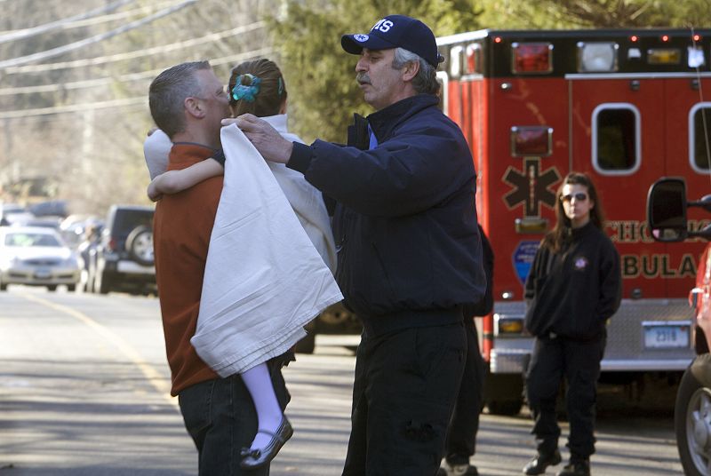 Una niña es cubierta con una manta tras el tiroteo en la  escuela Sandy Hook.