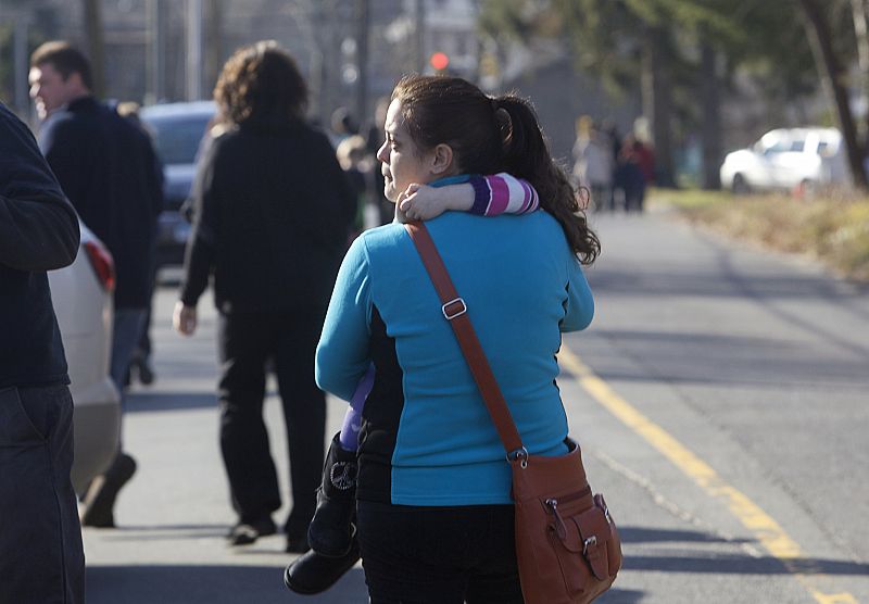 Una mujer con su hija en brazos tras el tiroteo de Connecticut