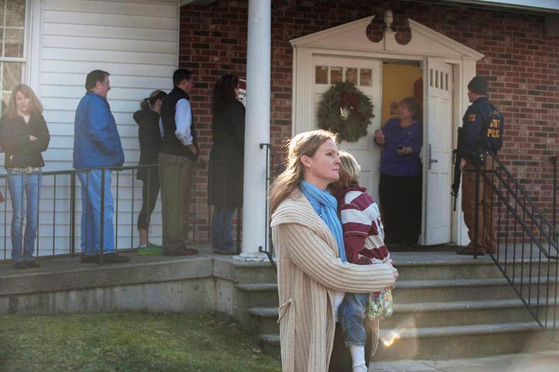 Una mujer sostiene en brazos a un niño en la entrada de la iglesia metodista de Newtown cerca del lugar del tiroteo