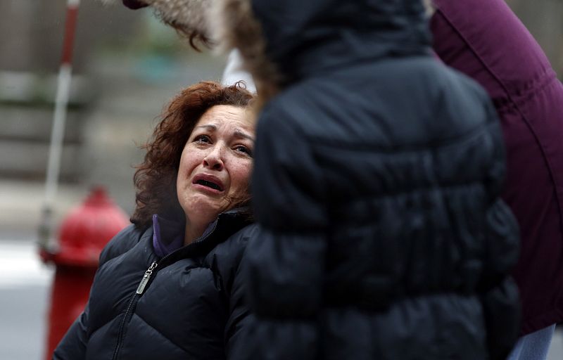 Woman cries as she pauses at a makeshift memorial near the Sandy Hook Elementary School for the victims of a school shooting in Newtown, Connecticut early Sunday December 16