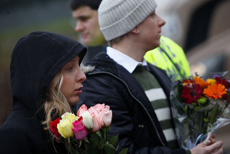 Una pareja lleva flores al improvisado memorial en Newtown, Connecticut, este 17 de diciembre