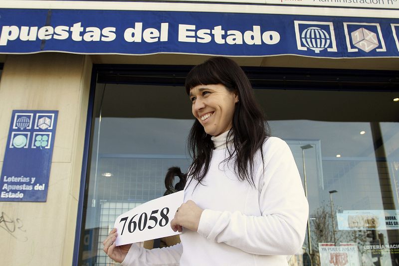 Una mujer muestra en Salamanca el número agraciado con el primer premio de la Lotería de Navidad