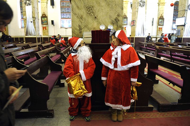 Niños vestidos de Papa Noel en una iglesia católica de Pekín