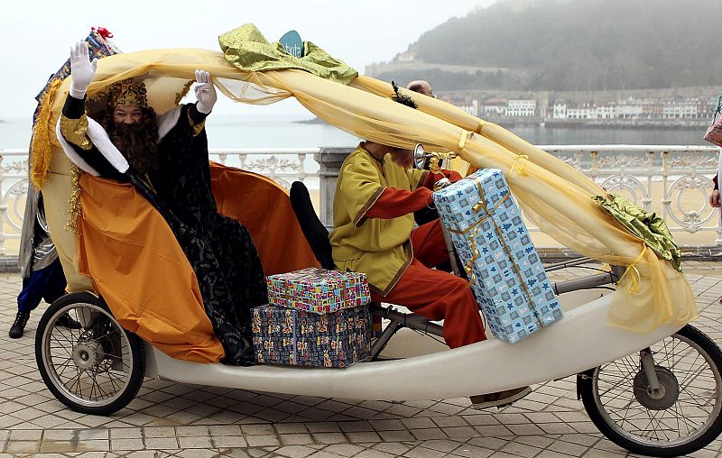 El rey mago Gaspar a su llegada a la playa de la Concha, en San Sebastián, montado en un triciclo que conduce un paje.