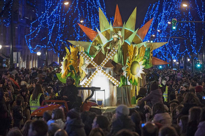 Numerosas personas al paso de una de las carrozas de la cabalgata de Reyes en Bilbao