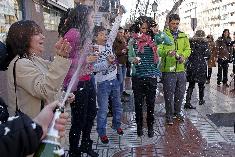 Varias personas muestran su alegría en Alcorcón, que ha repartido 40 millones de euros con el primer premio de la lotería del Niño.
