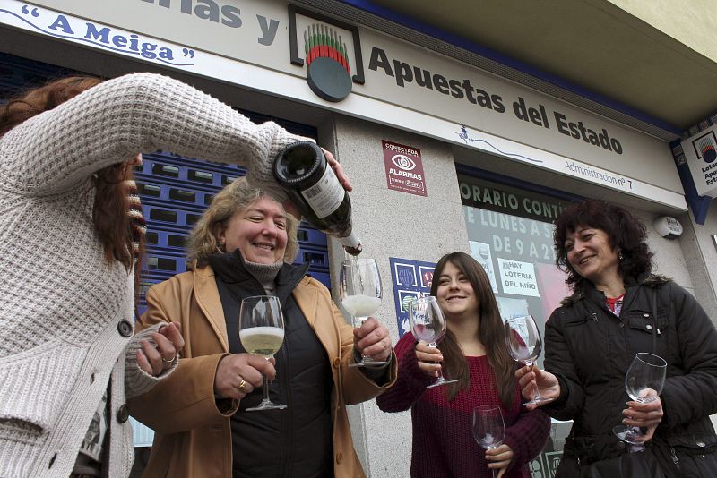Varias personas beben cava en las inmediaciones de una administración de loterías de Ponferrada que ha repartido dos millones de euros.