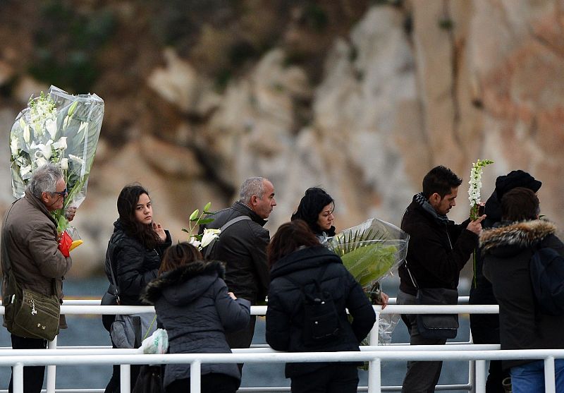 Lanzan flores en homenaje a las víctimas del Costa Concordia en la isla de Giglio, donde el buque sigue encallado un año después