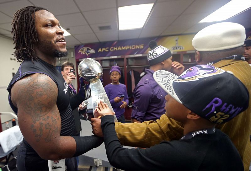 Courtney Upshaw #91 de los Baltimore Ravens en el vestuario con el trofeo de la Super Bowl XLVII