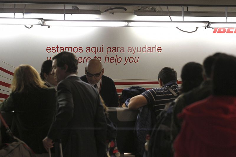 Numerosos pasajeros buscan información en los mostradores de Iberia en Barajas