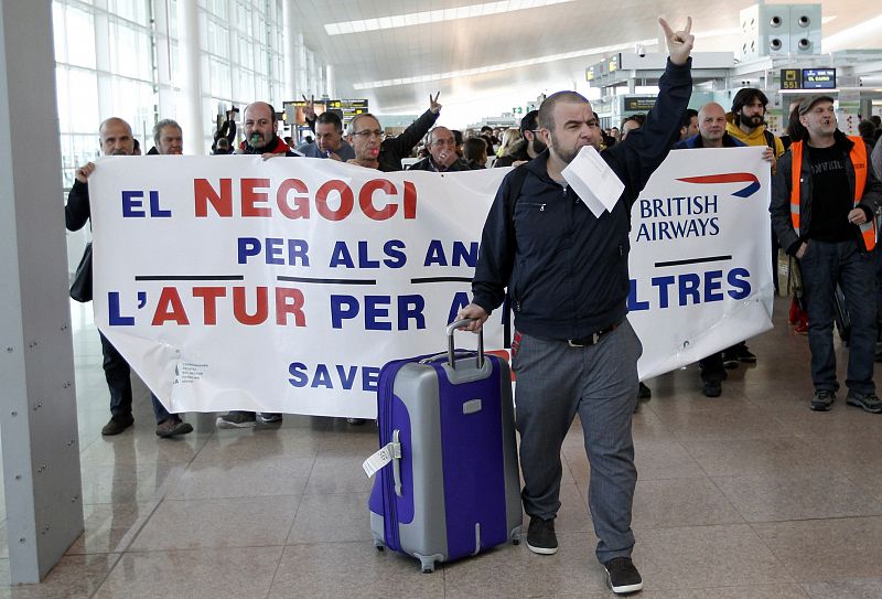 Un pasajero gesticula delante de un grupo de trabajadores de Iberia en la T1 del aeropuerto de Barcelona