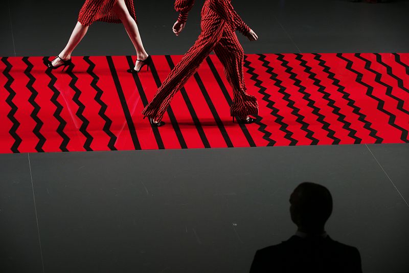 A man looks at models presenting creations from Ailanto's Fall/Winter 2013 collection during the Mercedes-Benz Fashion Week in Madrid