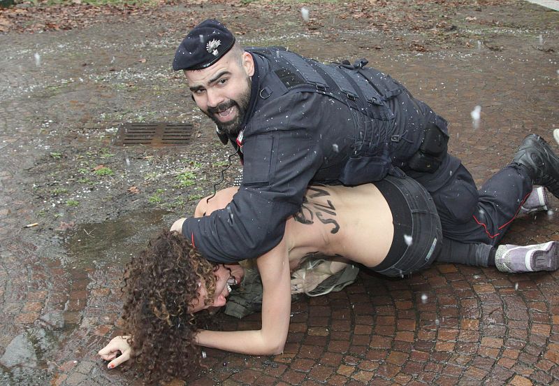 Un policía retiene a una de las activistas en Milan